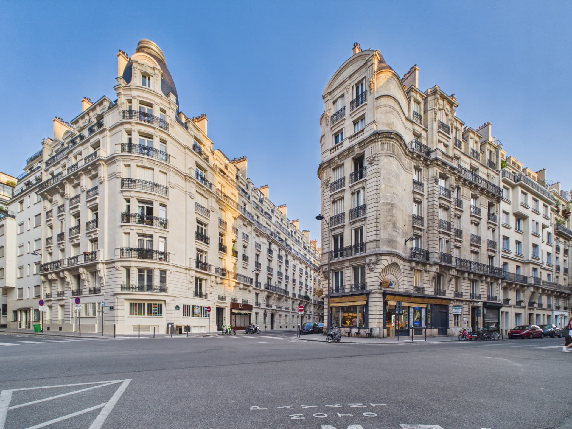 Deux immeubles haussmanniens en pierre à un carrefour parisien